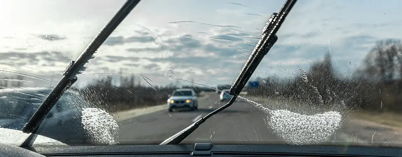 Wipers removing rain on a car windshield